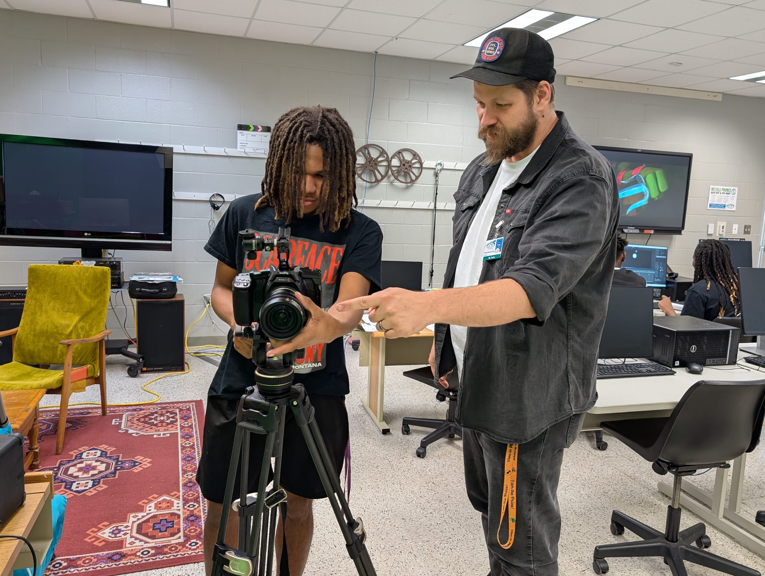 Mr. Treme teaching a student how to use a camera.